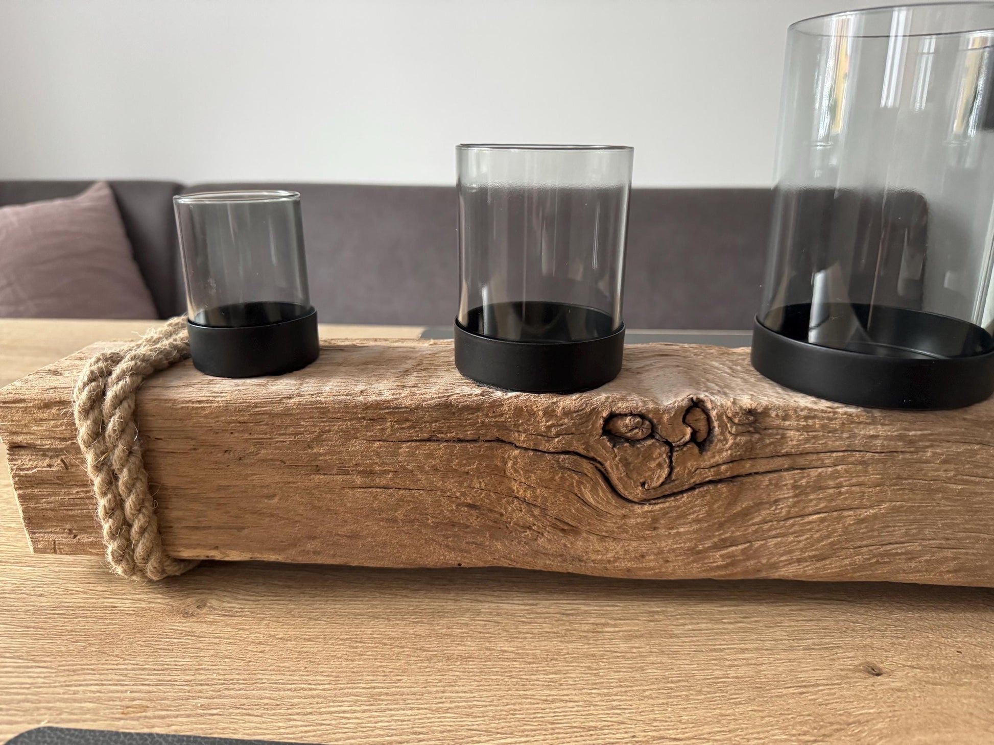 Treibholz Adventskerzenhalter mit vier brennenden Kerzen und Glaszylinder im skandinavischen Weihnachtsambiente.