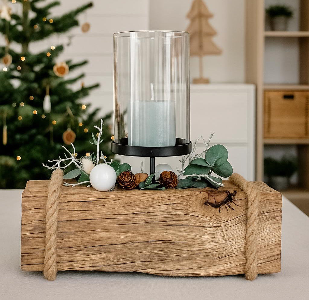 Rustikaler Kerzenhalter aus Eichenholz mit einer brennenden Kerzen und Glaszylinder im skandinavischen Weihnachtsambiente.