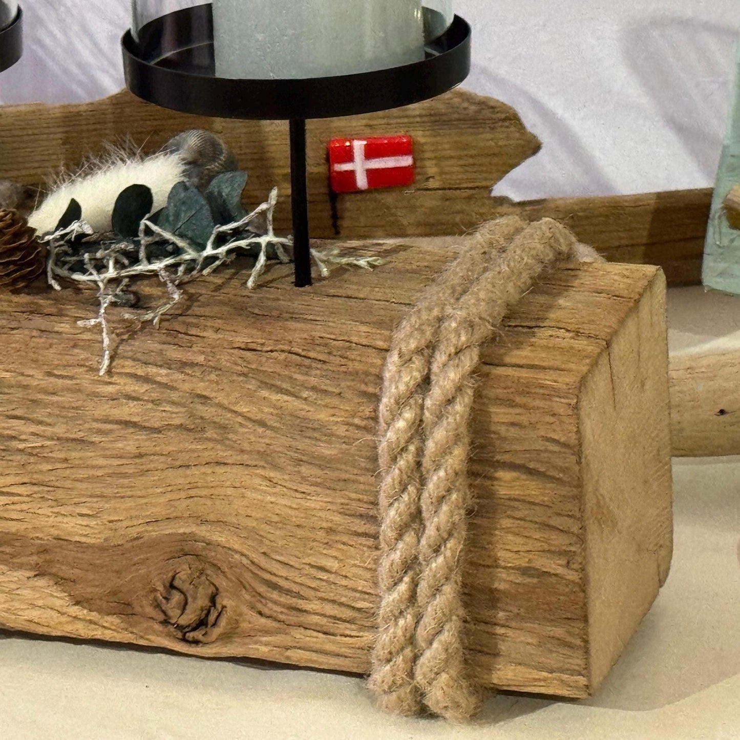 Nahaufnahme von einem rustikalen Treibholz Kerzenhalter 55 cm aus Holz mit vier in Glas eingeschlossenen Kerzen.