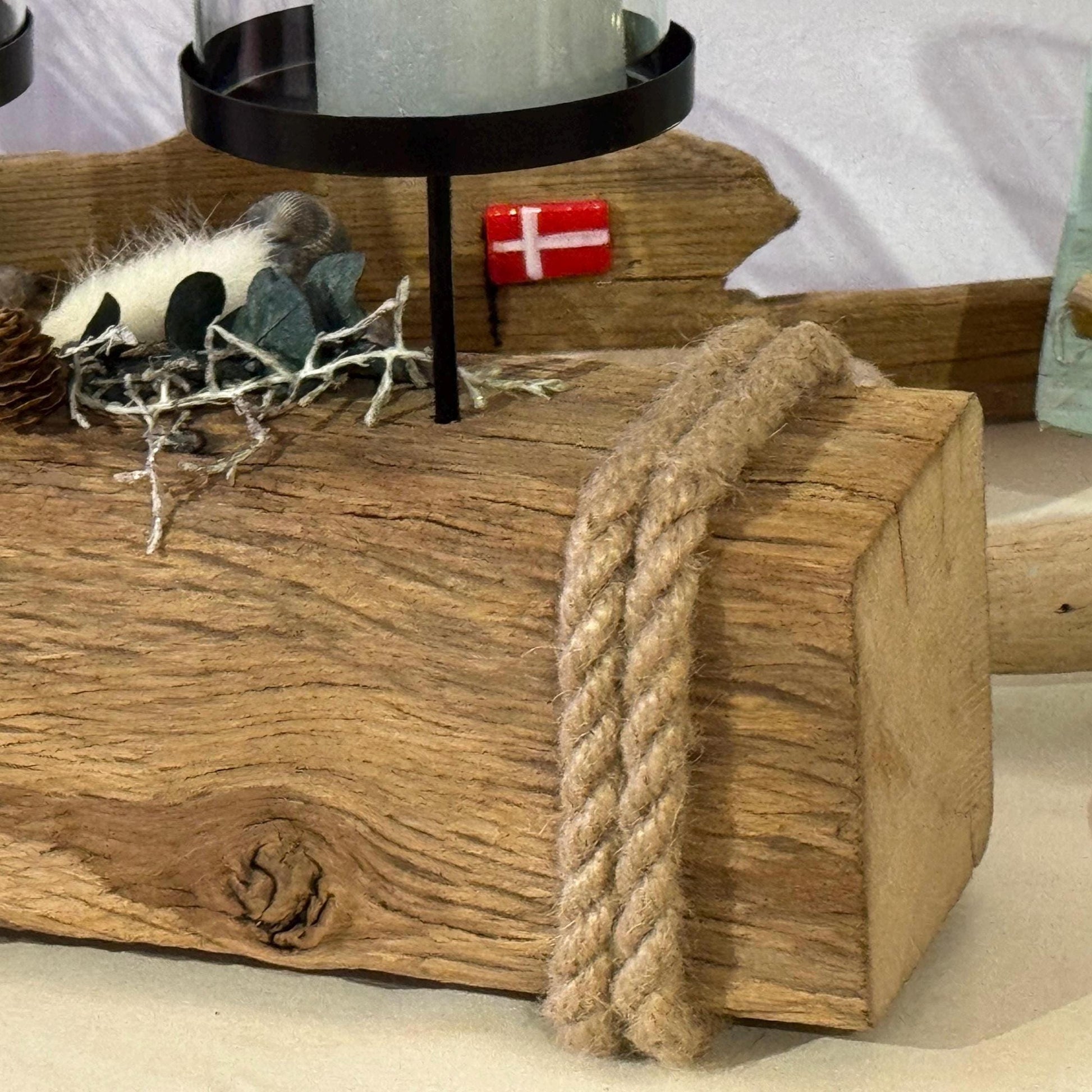 Nahaufnahme von einem rustikalen Treibholz Kerzenhalter 55 cm aus Holz mit vier in Glas eingeschlossenen Kerzen.