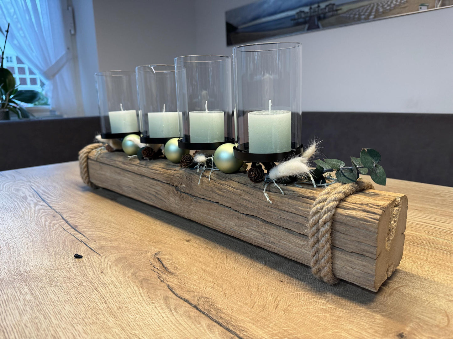 Treibholz Adventskerzenhalter mit vier brennenden Kerzen und Glaszylinder im skandinavischen Weihnachtsambiente.