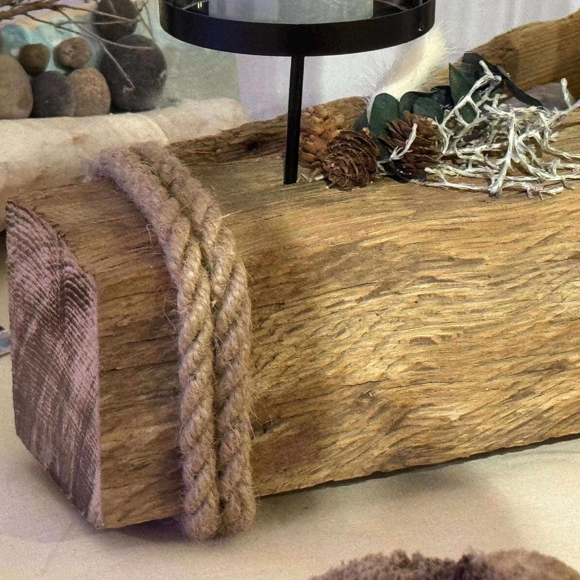 Nahaufnahme von einem rustikalen Treibholz Kerzenhalter 55 cm aus Holz mit vier in Glas eingeschlossenen Kerzen.