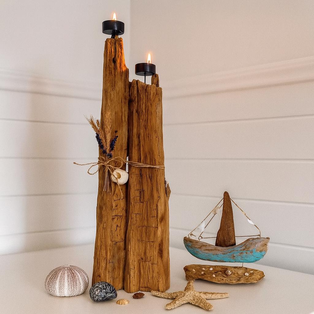 Ein rustikaler Kerzenhalter aus Holz mit zwei schwarzen Kerzenschalen, verziert mit Trockenblumen und einer Muschel.