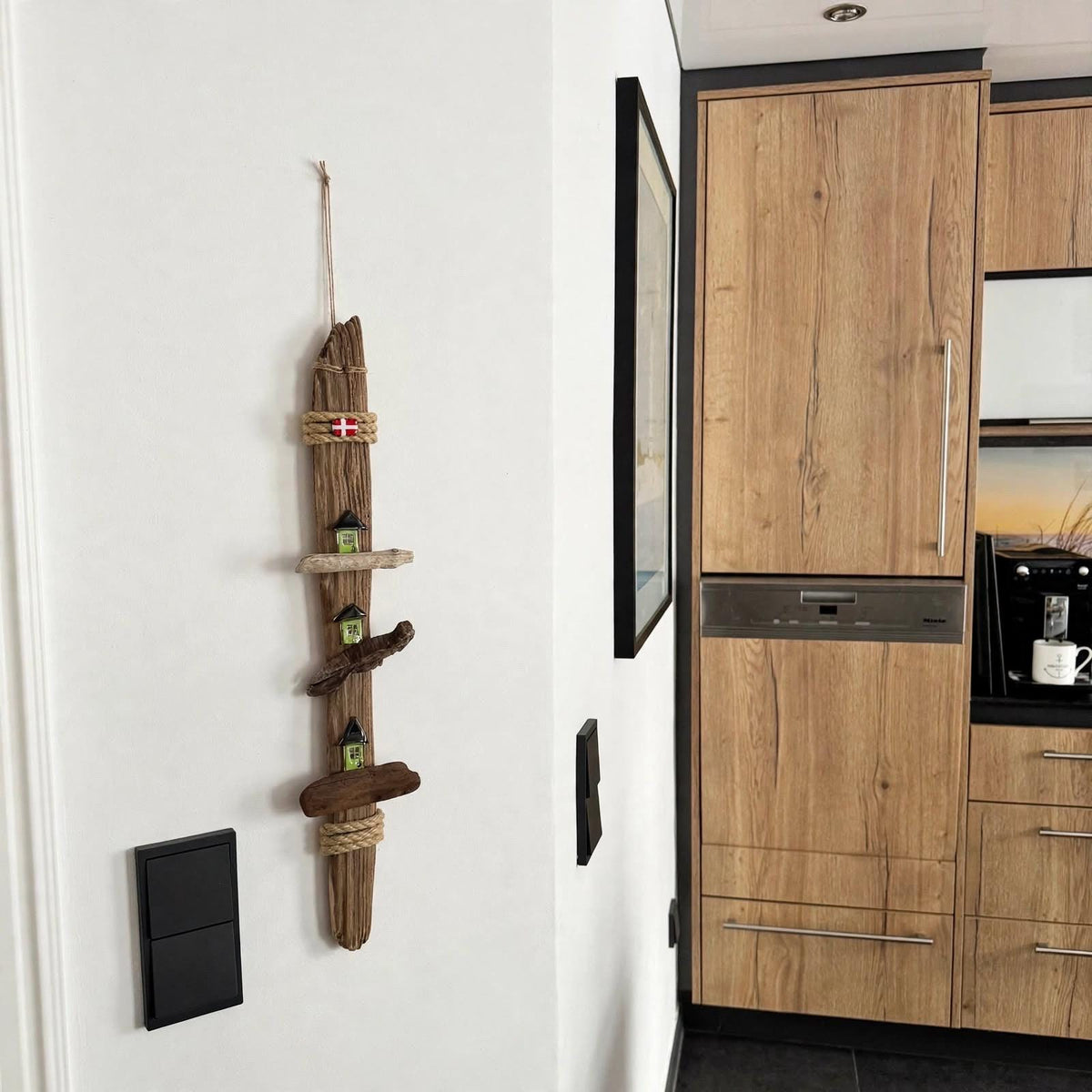 Treibholz Deko hängt an weißer Wand in Küche neben Holztür, Wohnbeispiel