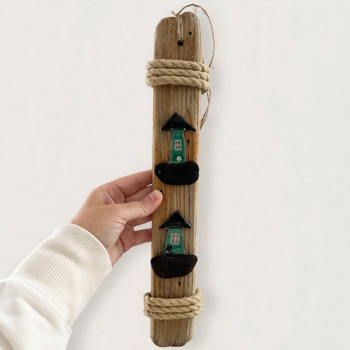 Hand hält 40cm Treibholz Hänger mit grünen Glas Häusern zum Größenvergleich - große Wanddeko