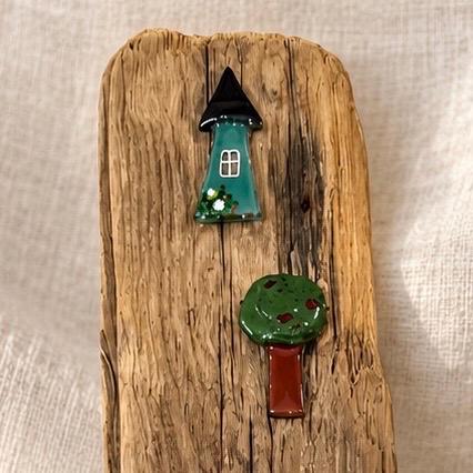 Detail oben Treibholzbild - grünes Glashaus mit schwarzem Dach und weißem Fenster und kleiner grüner Baum auf Holz