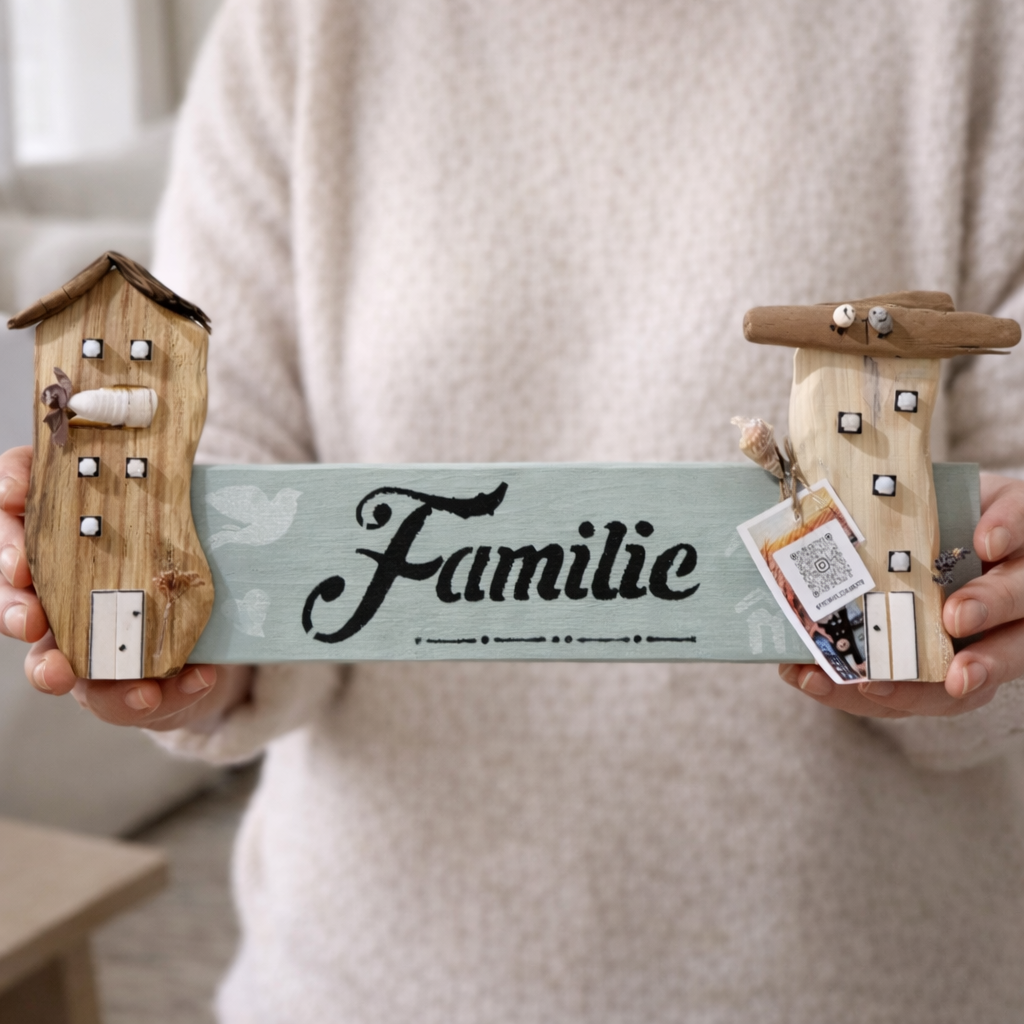 Hand hält maritime Familie Wanddeko aus Holz mit Treibholz Häusern von Treibholzzauber79